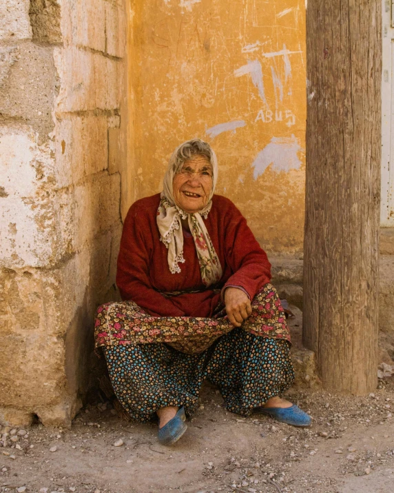 a woman wearing blue shoes sitting next to a yellow wall