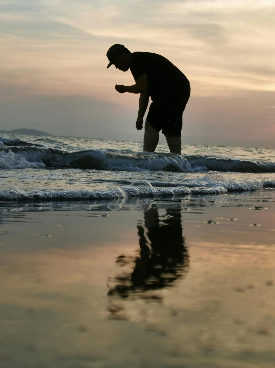 the man is walking in the water at the beach