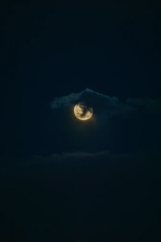 a full moon rising over a mountain range