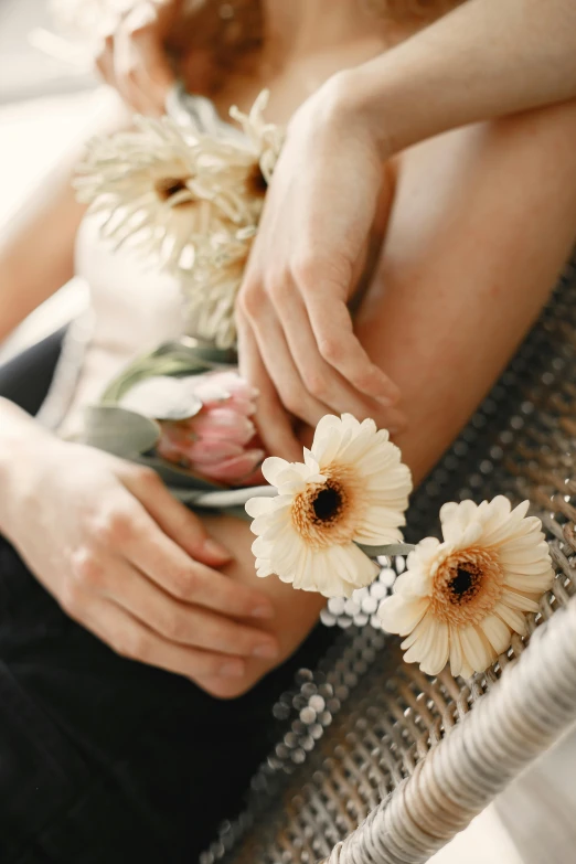 woman holding flowers while sitting down on chair