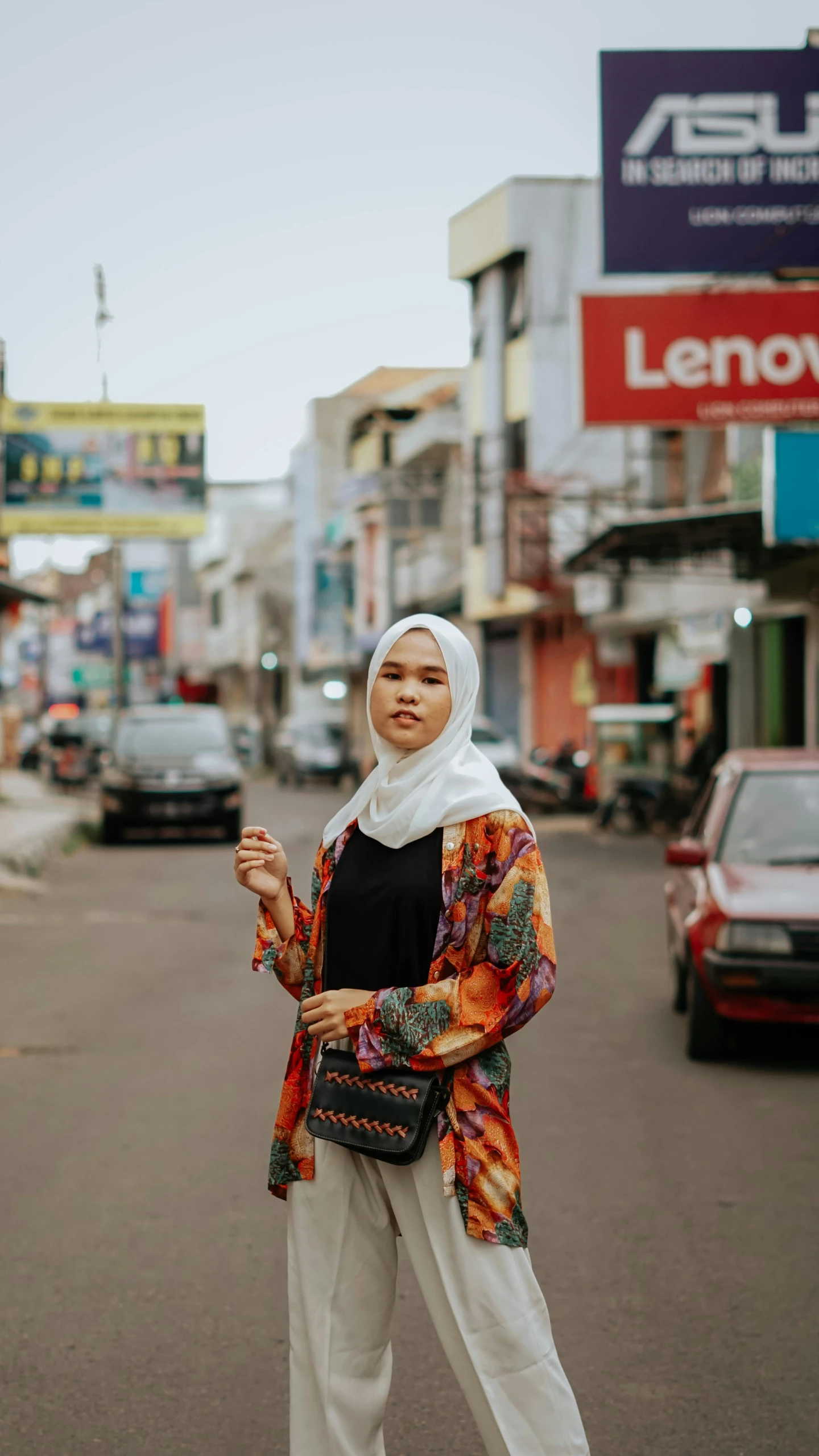 a woman wearing white pants and black top on street corner