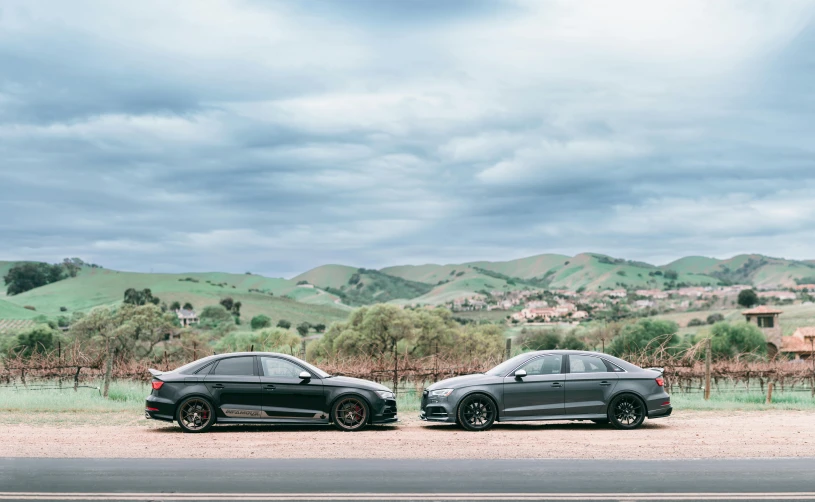 two cars parked near each other on a dirt road