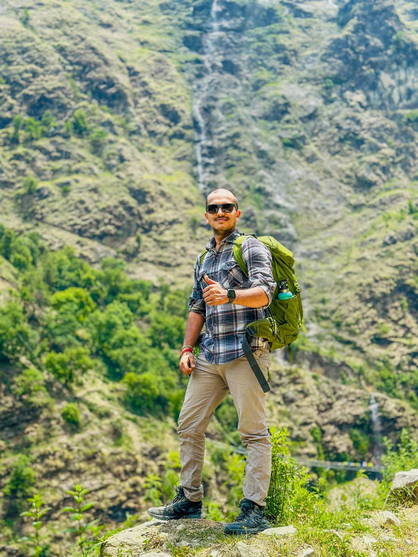 a man with a backpack standing on top of a mountain