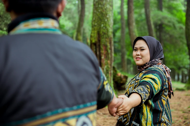 a young person in the woods shaking hands