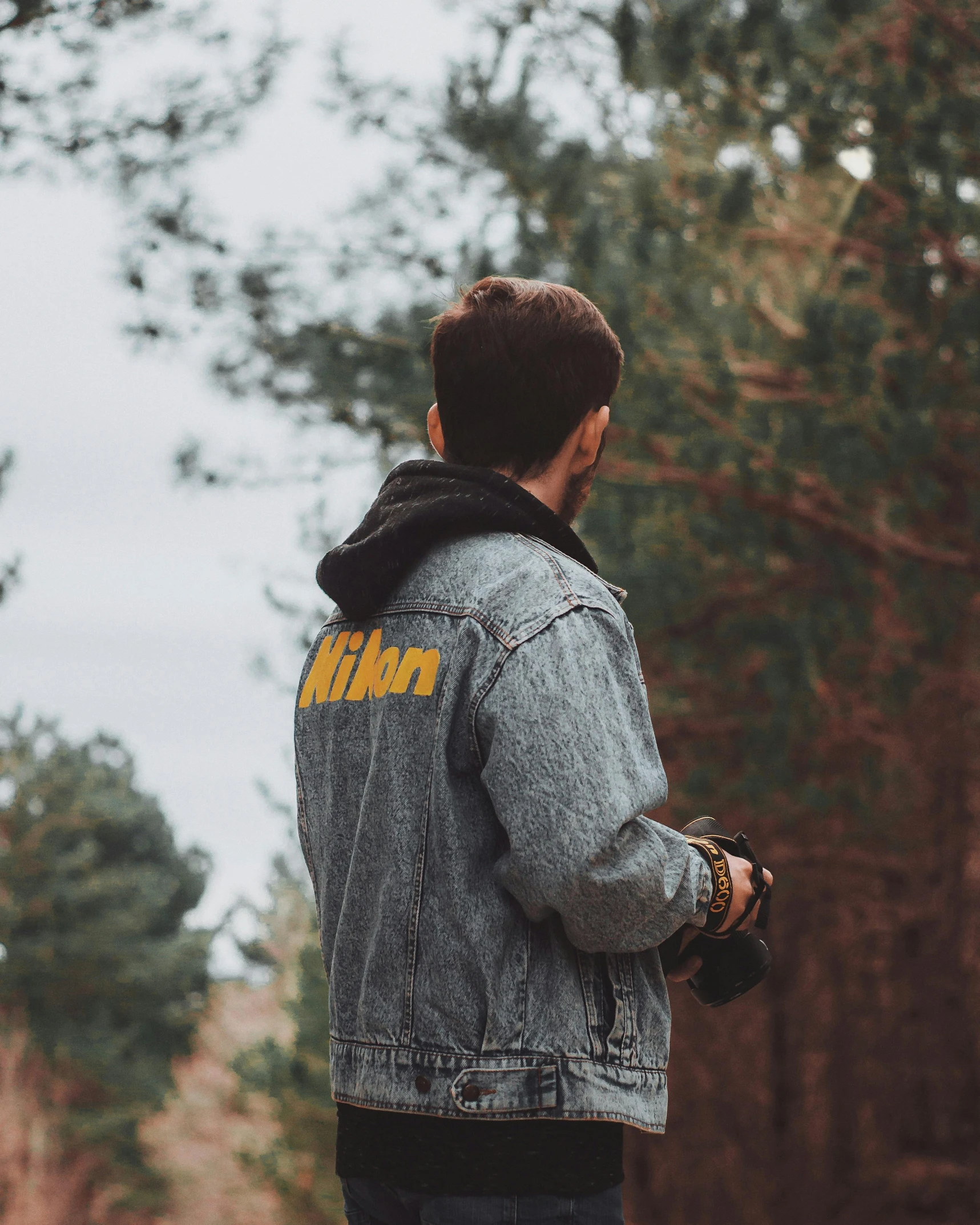 a man wearing a levi jacket in the woods