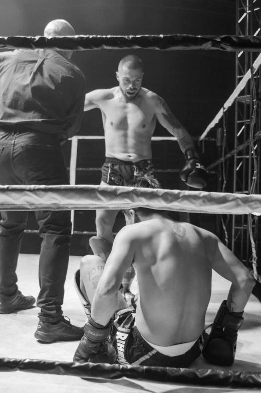 the referee and three men stand on a wrestling ring