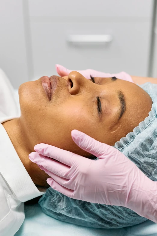 a lady is doing a facial procedure with medical equipment
