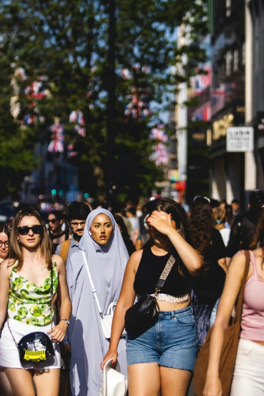 a group of women walk down the street in a city