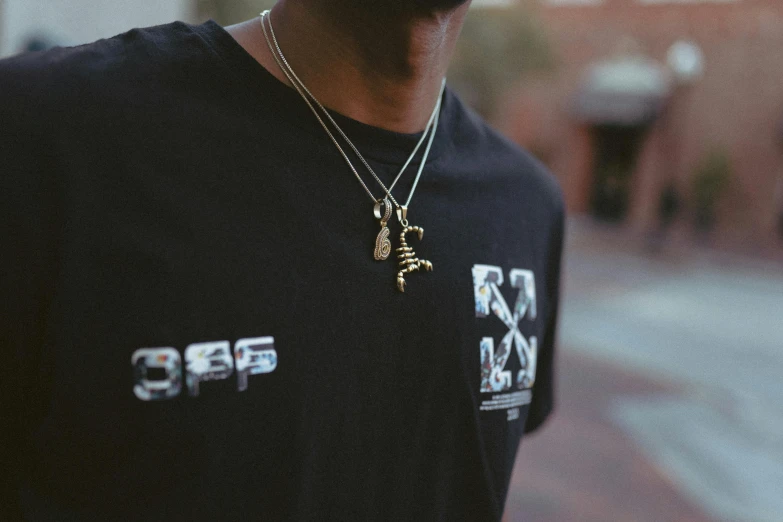 the young man wearing the shirt has a small pendant