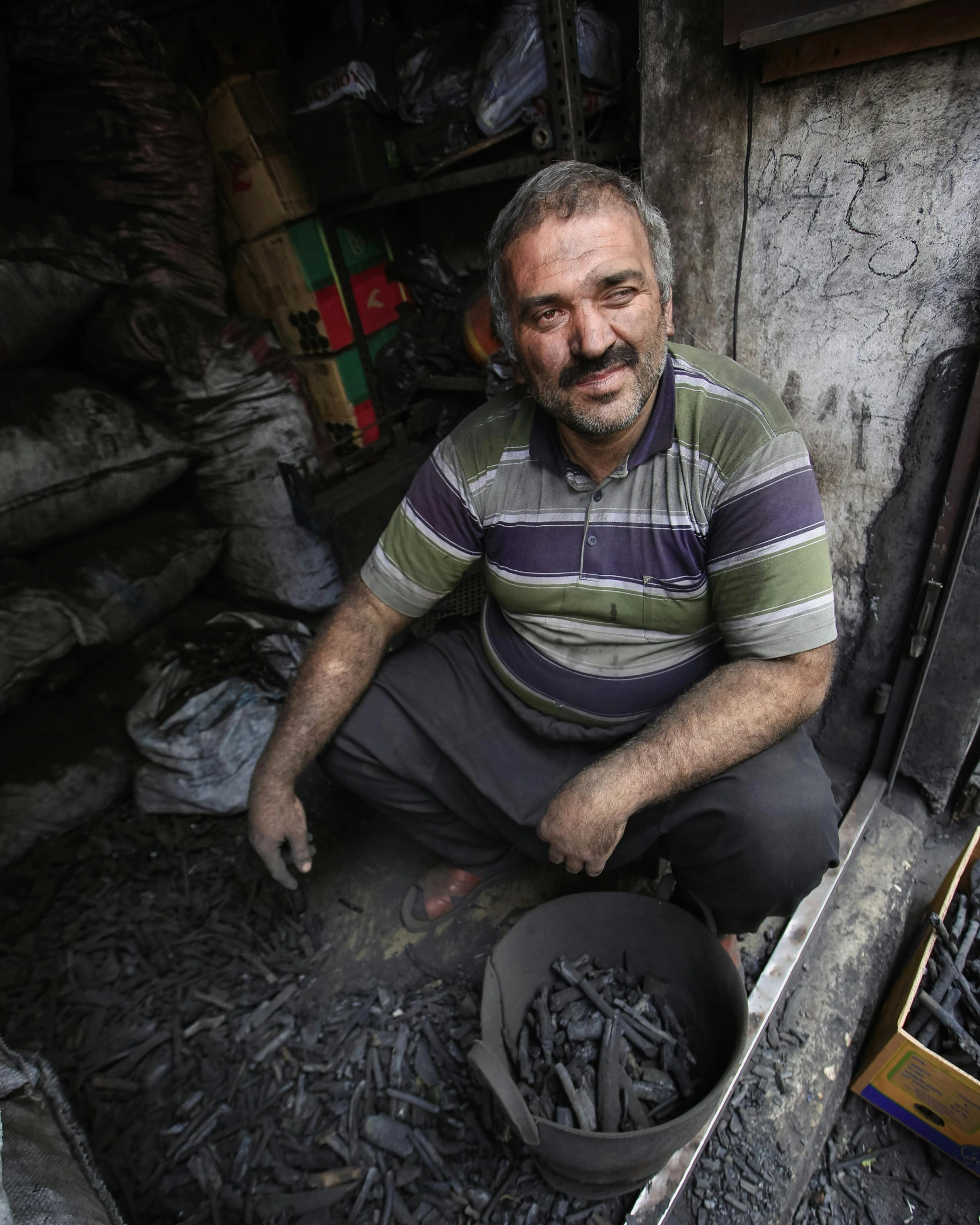 man sitting in an open area filled with wood