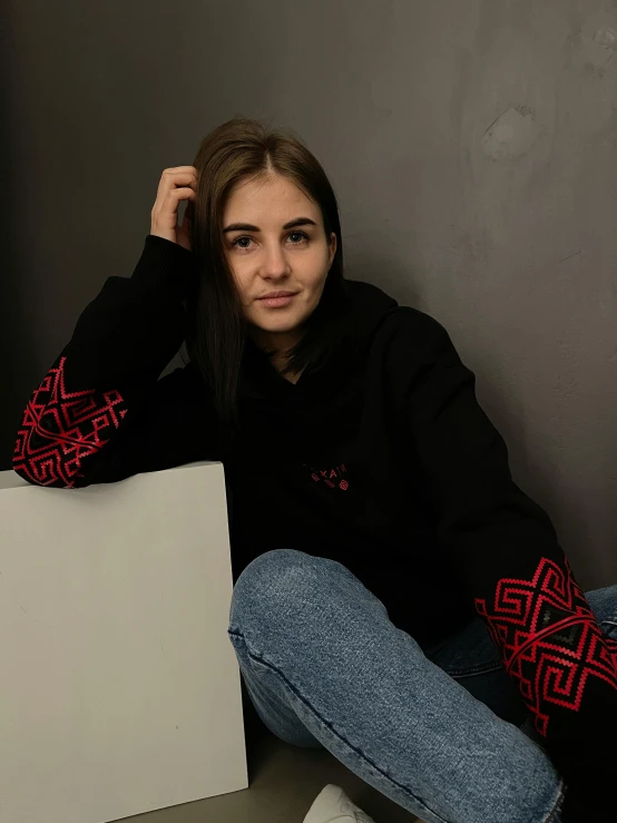 a young woman sitting on top of a table next to a white box