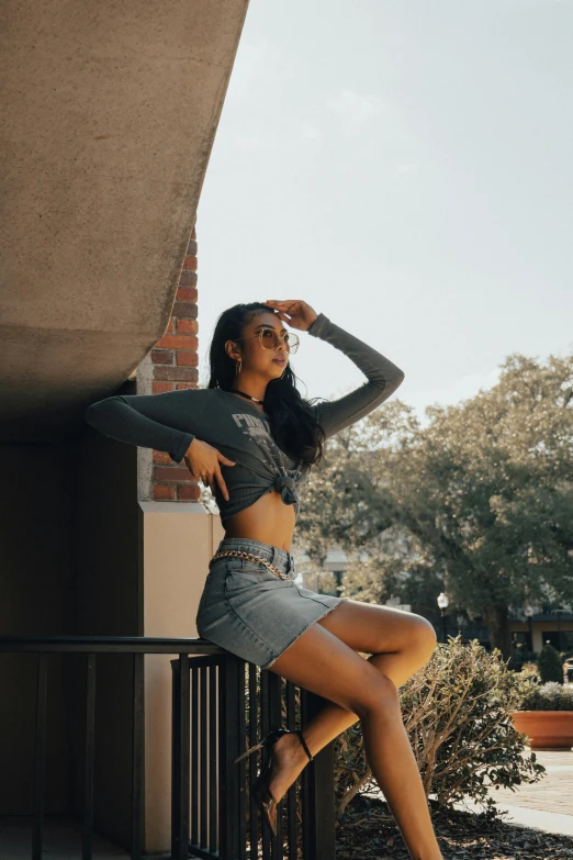 a woman is sitting on the balcony with her legs crossed