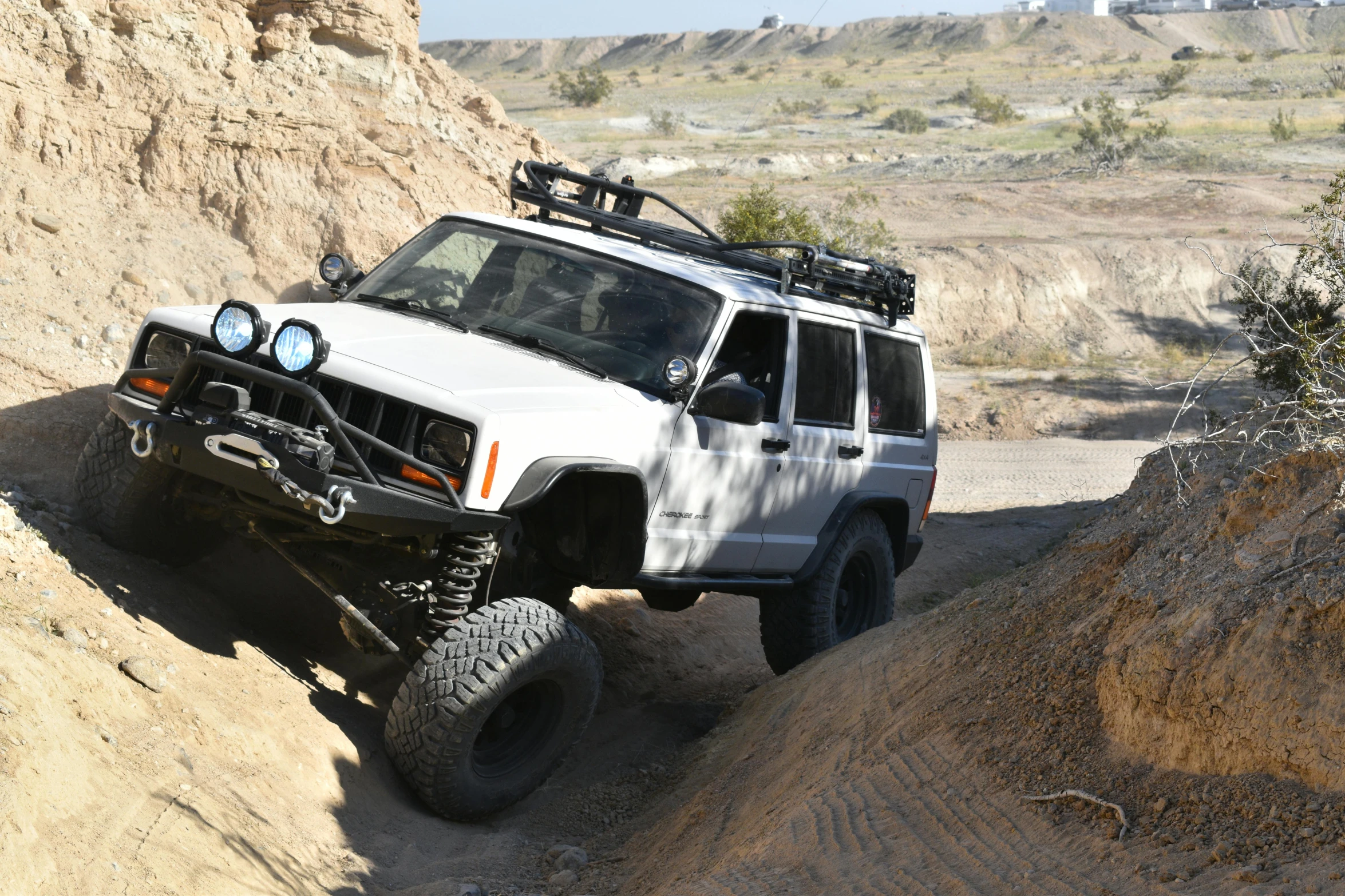 a jeep is driving along the road on a rocky cliff