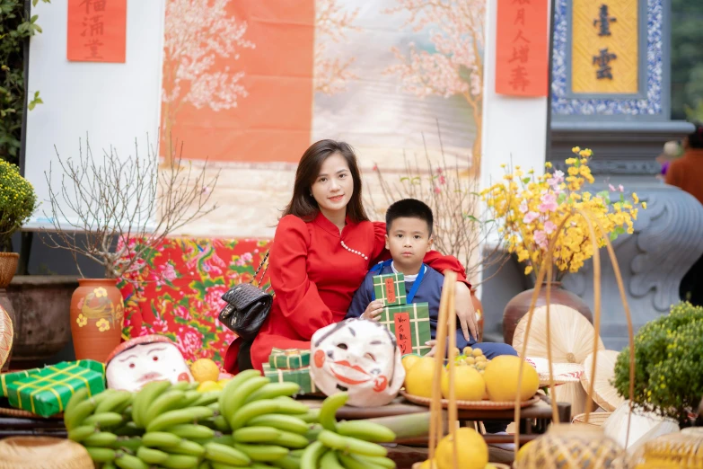 two people sitting down with different kinds of vases and fruit