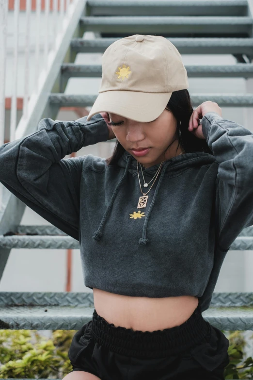 a young woman standing next to some stairs with her hat on