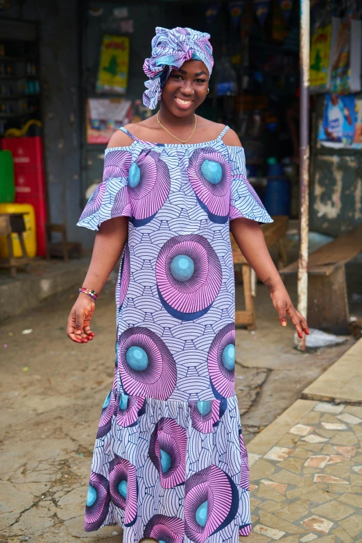 a woman in purple dress standing on street