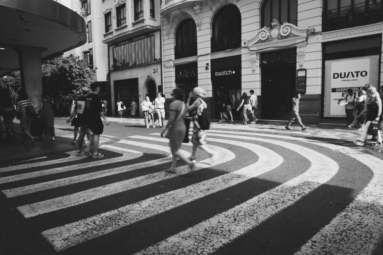 several people cross the street as they walk on the pavement