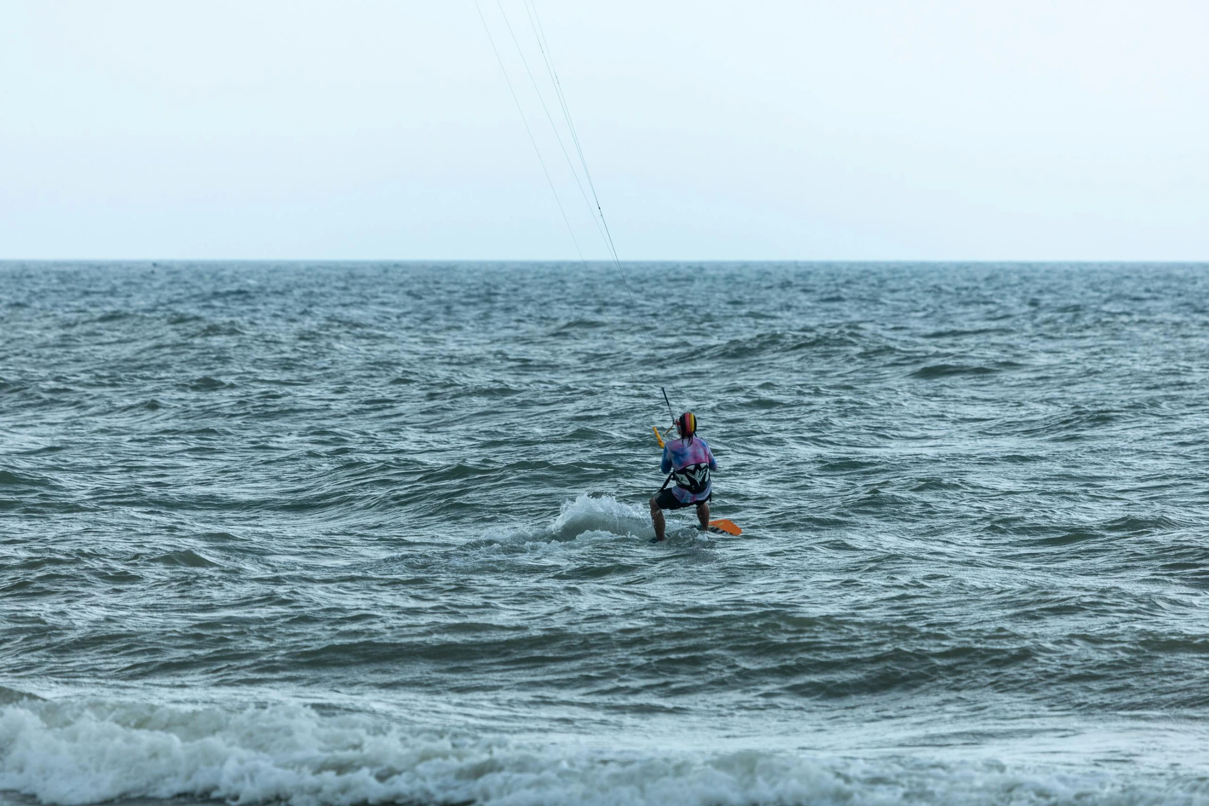 a man is flying a kite over the water