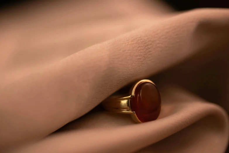 a gold ring on a bed sheet