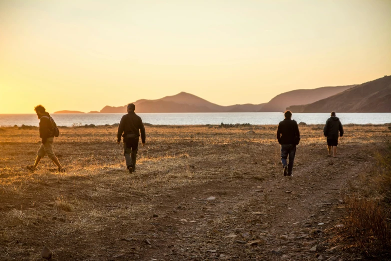 several people walking away into the sunset