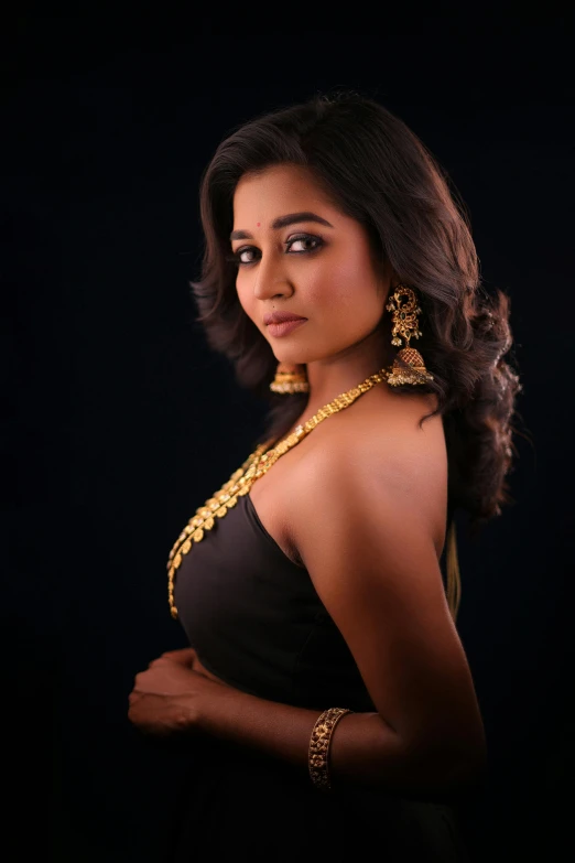 a young woman in egyptian jewelry looks into the camera