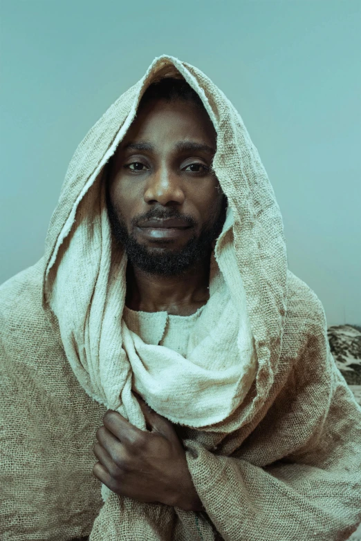 a black man with a beard under a white blanket