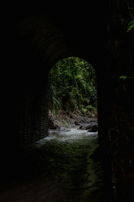 a river coming out of a dark tunnel