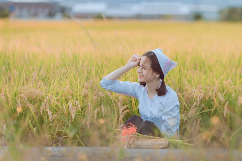 woman with white blouse and black hat sitting in grass looking through the binoculars