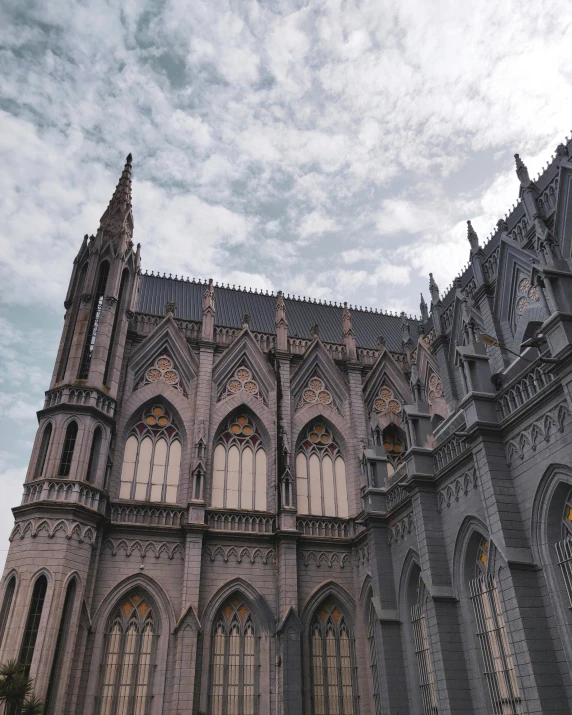 a very tall cathedral towering above a cloudy sky