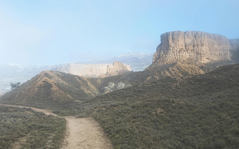 a mountain scene with a trail through the side