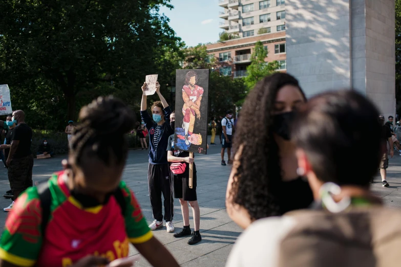 two people are protesting and one is holding a sign