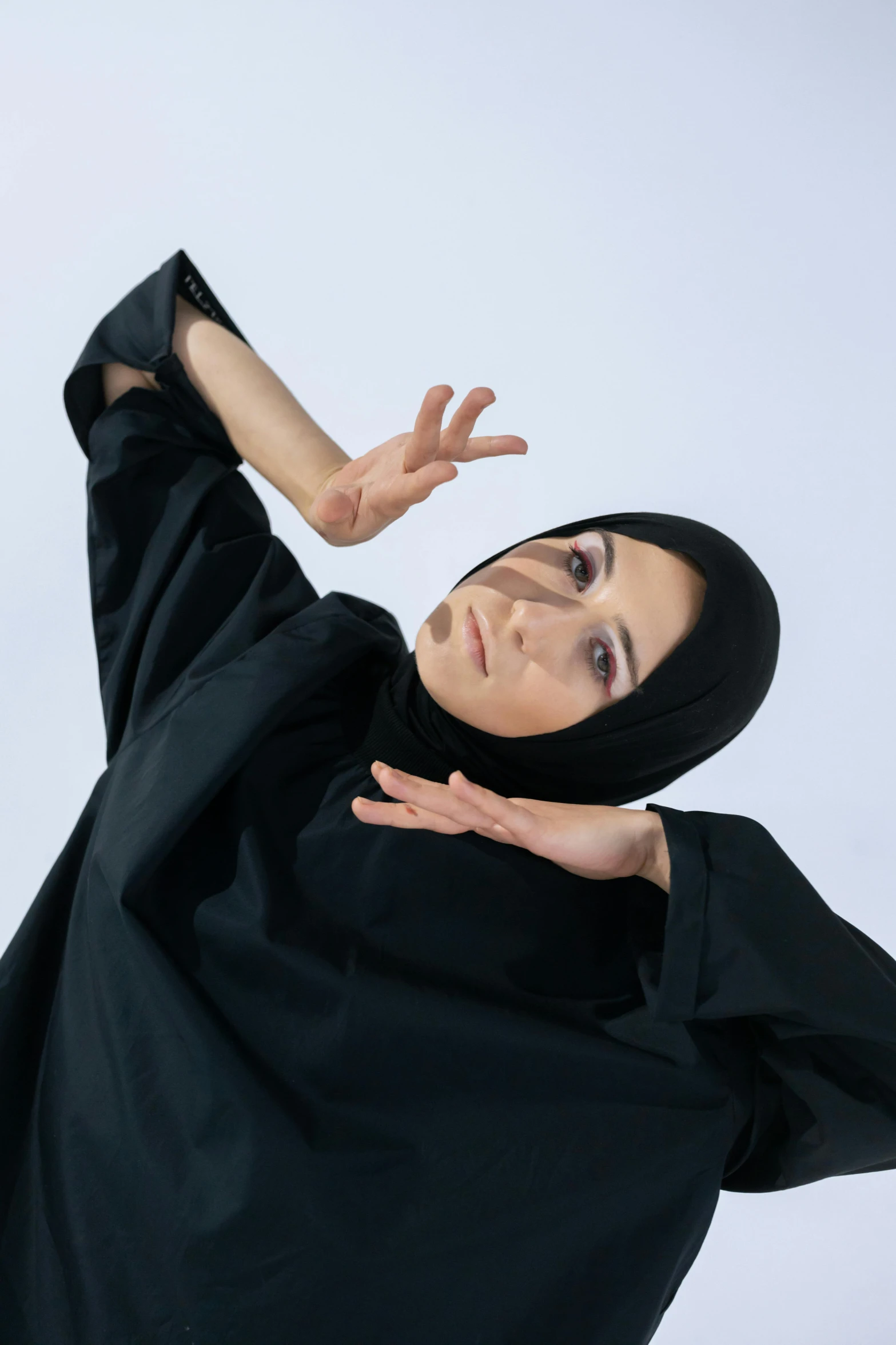 woman wearing black on her head, arms and feet spread out to the side