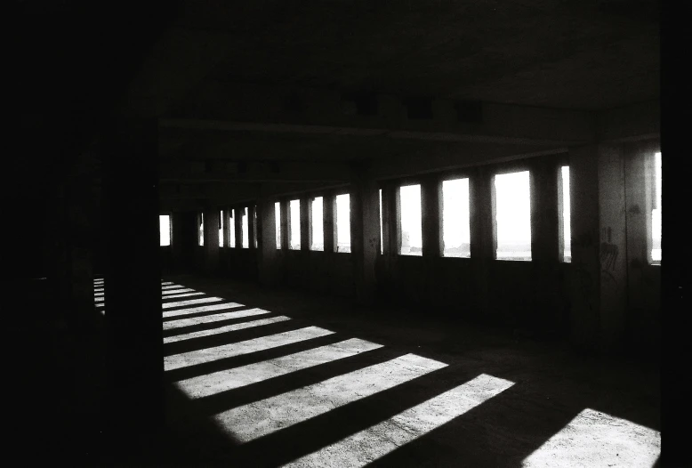 a room that has multiple windows and long shadows