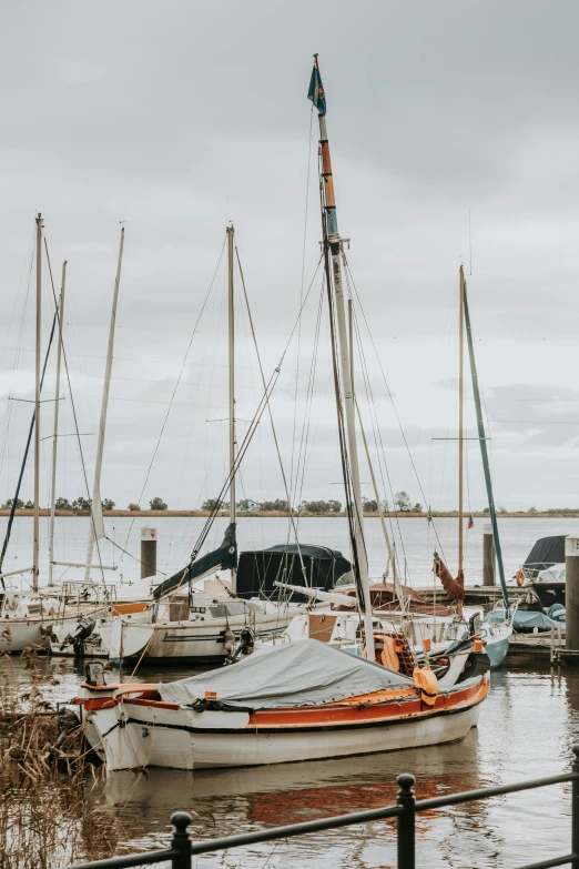 boats in the water near a dock, with people looking on