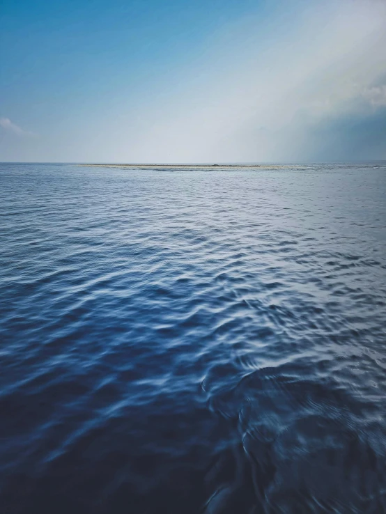 there is an ocean with some small islands in the distance