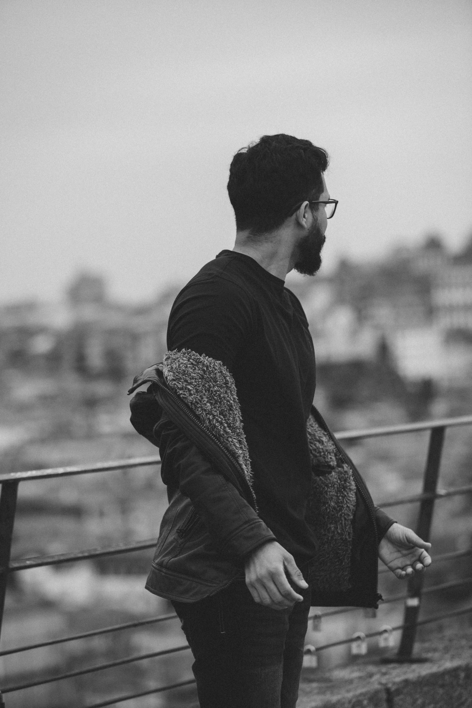 a man stands on a ledge looking over the city