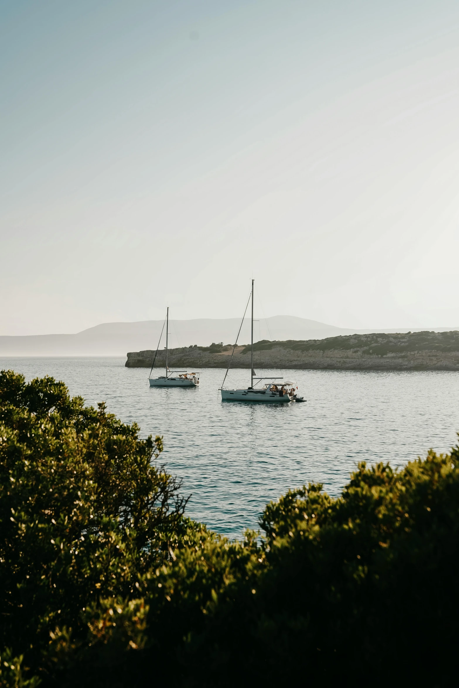 three sail boats that are floating in the water