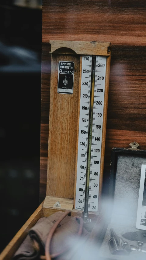 thermometer lies on a wooden box next to an electronic device