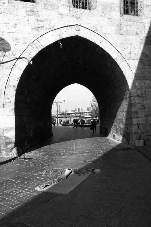 two people walk in a tunnel beside a bench