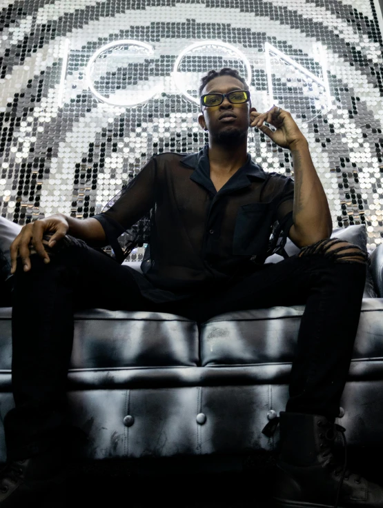 a man sitting on a couch in front of a mosaic pattern