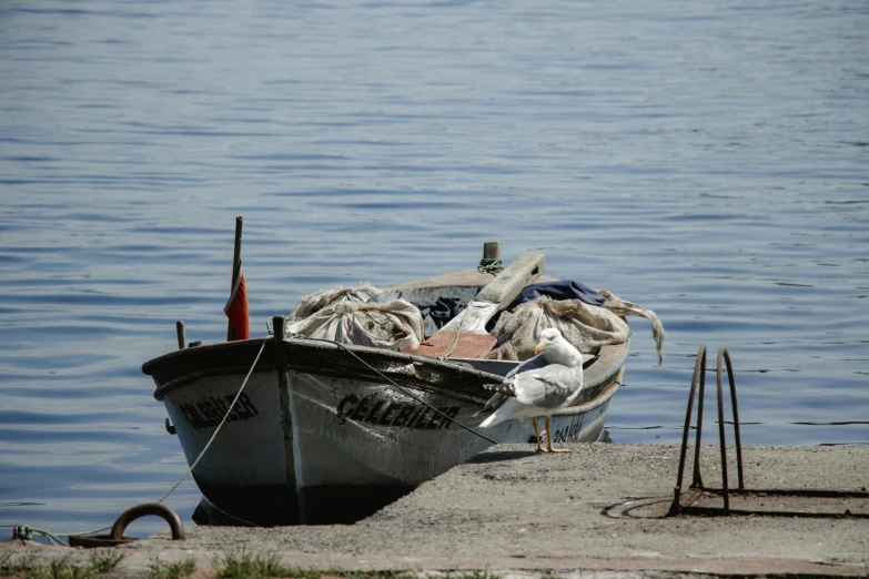 an old boat is on the shore next to a body of water