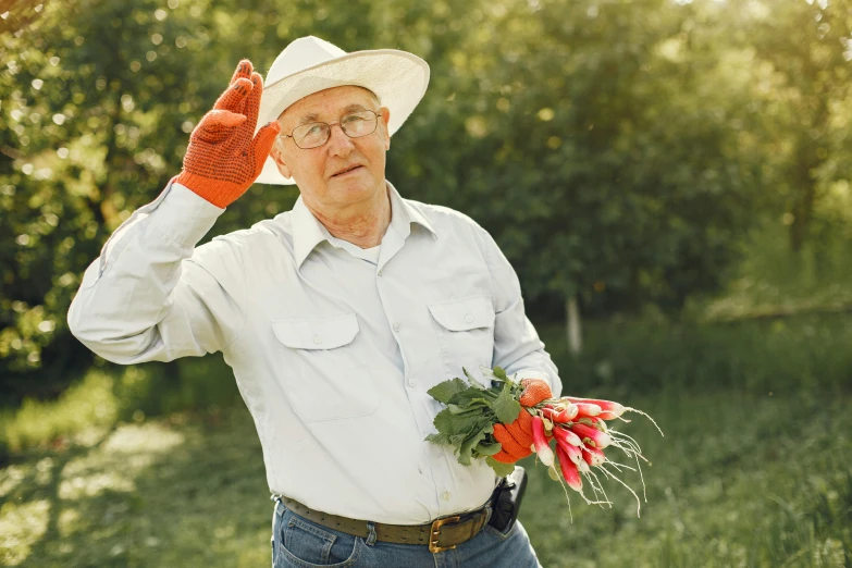 a older man in his 40s wearing glasses and cowboy hat holding a flower