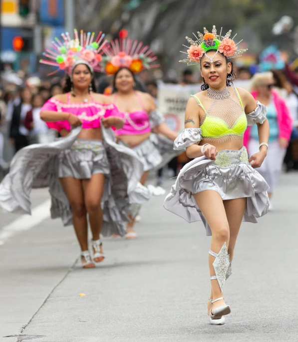 women dressed in costumes walk down the street