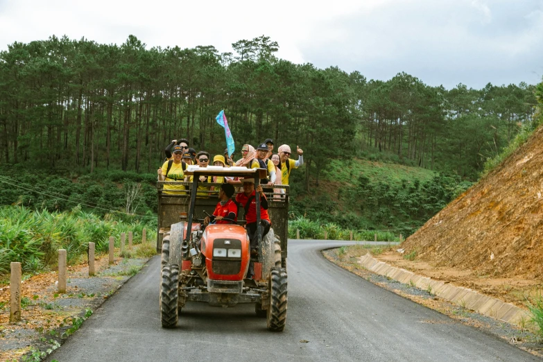 two tractor drivers with passengers traveling down a country road