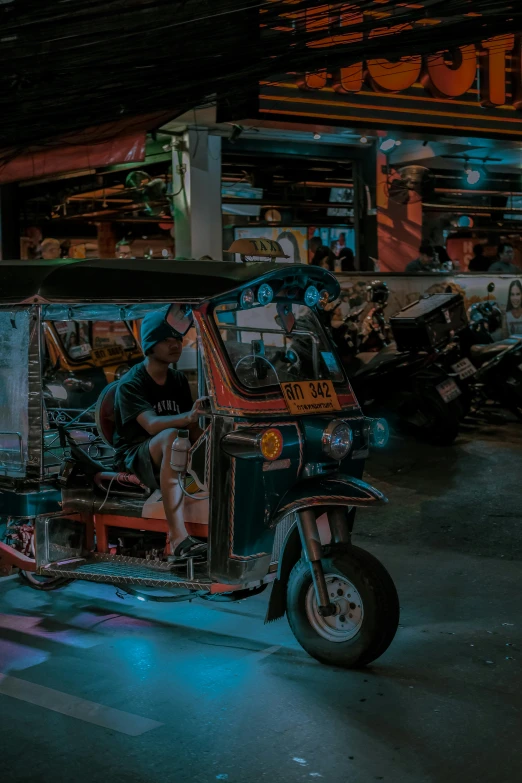 a man in blue shorts is on an auto rickshaw