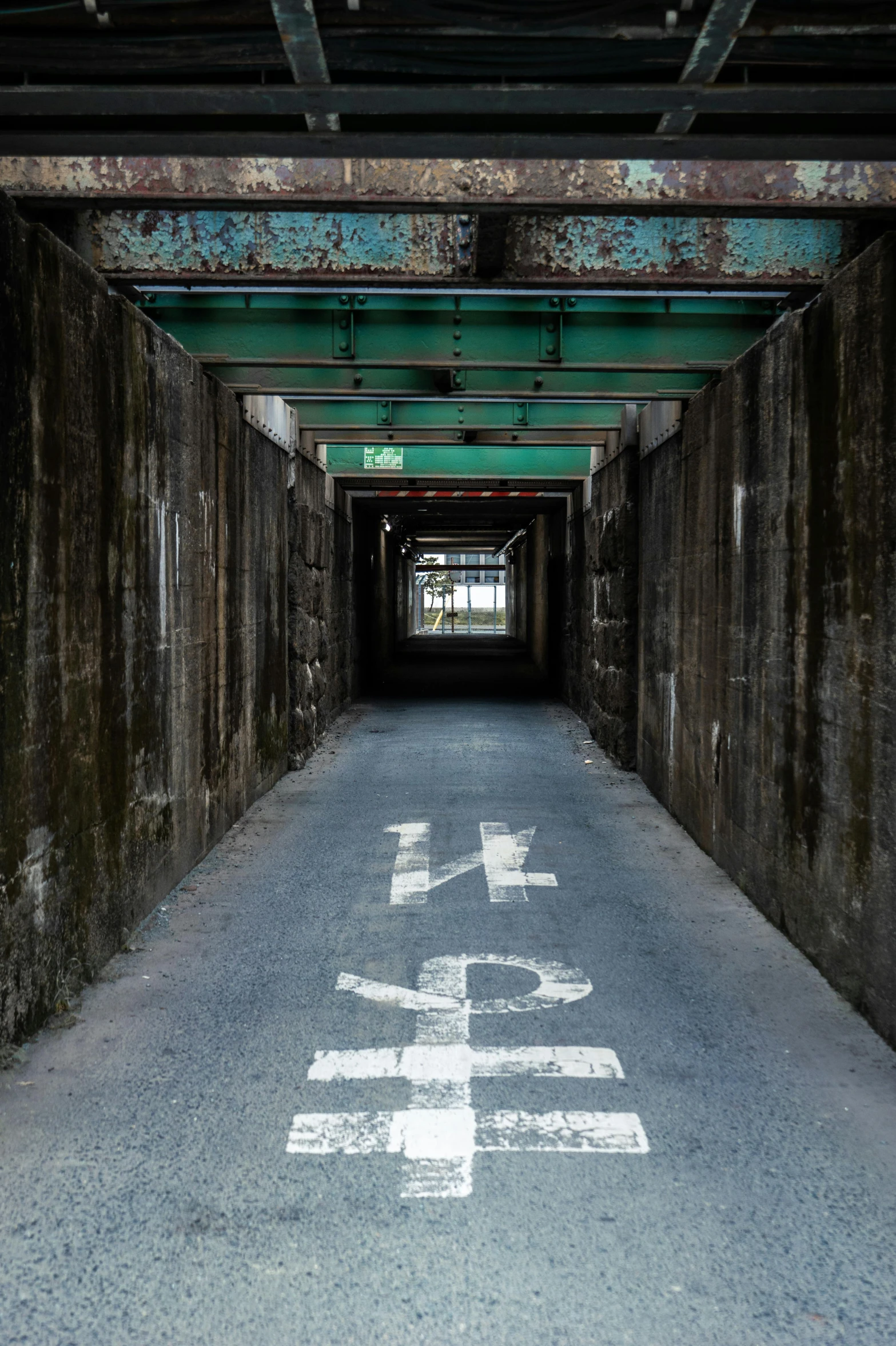 an empty road with graffiti written in the middle of it