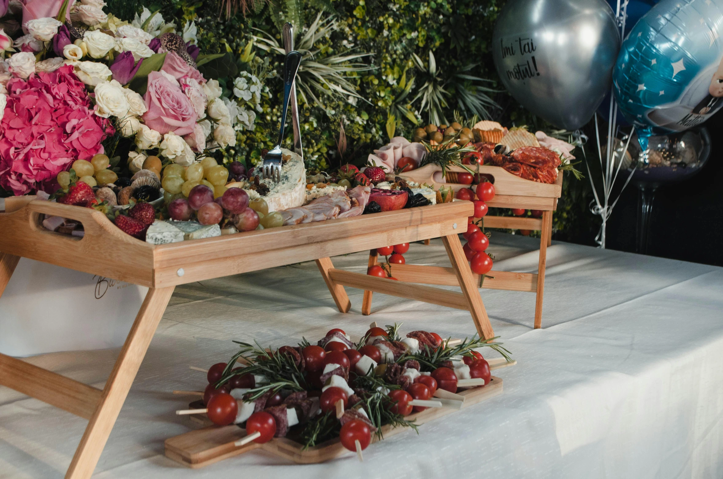 a wooden stand with fruits on it next to balloon