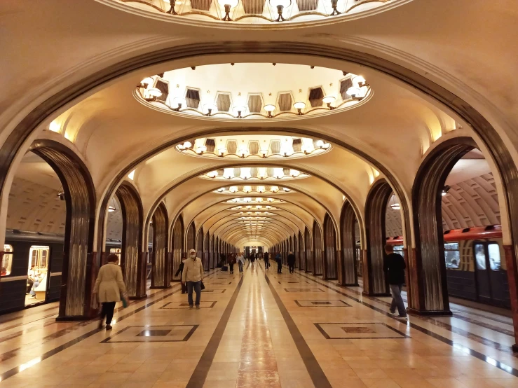 people are walking on the hallway in the train station