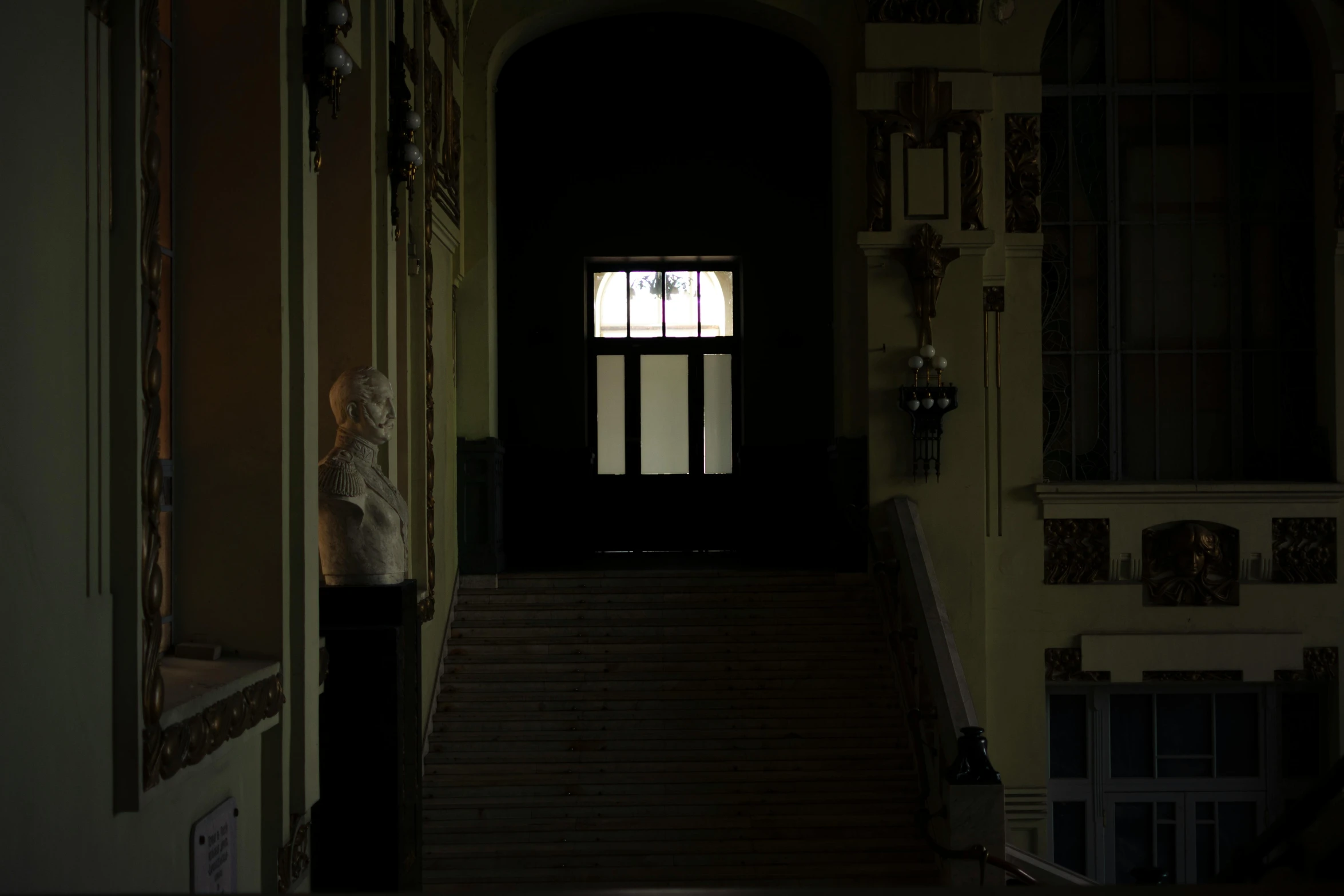 an open door leading to a hallway with wooden stairs