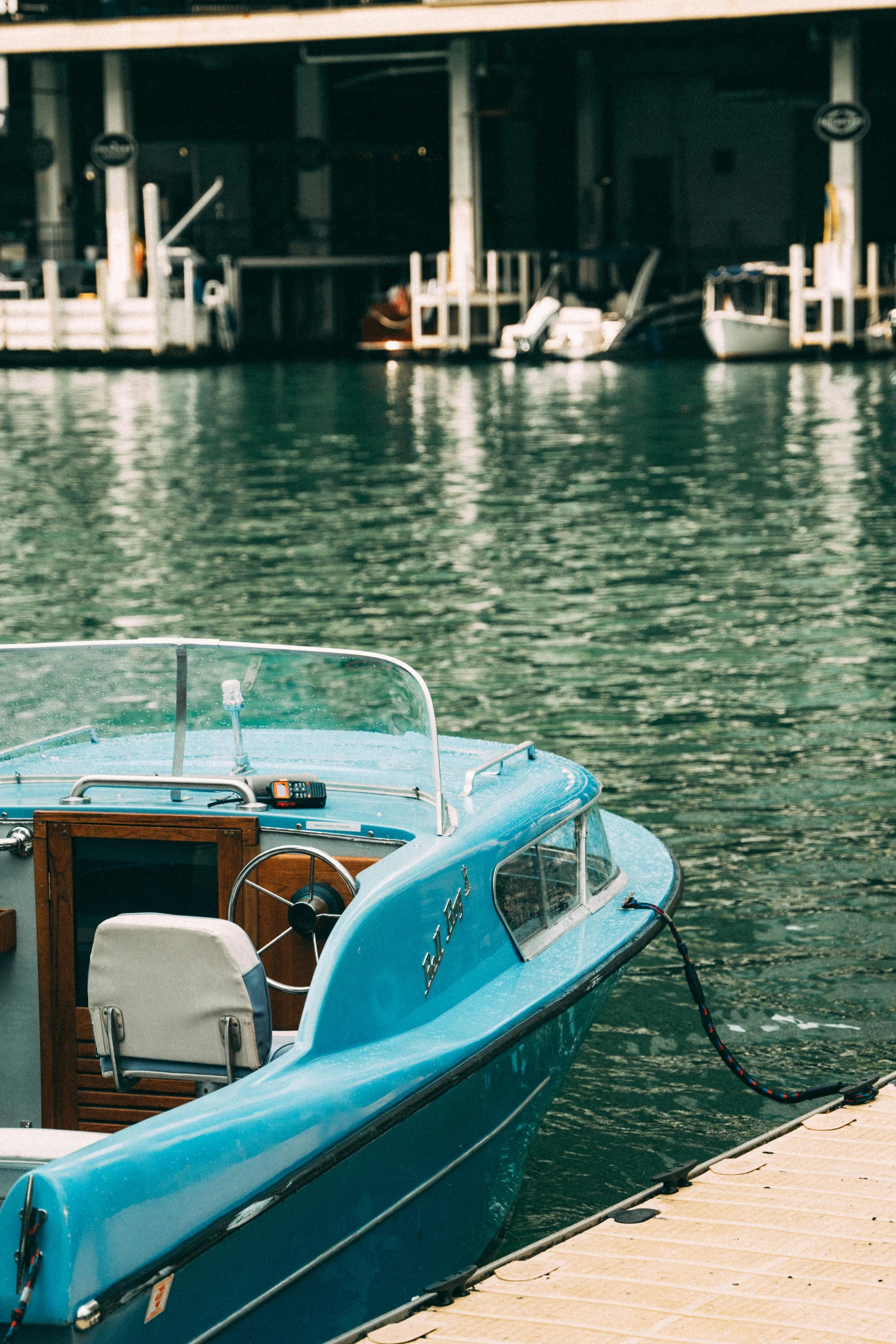 a small blue boat docked by a dock